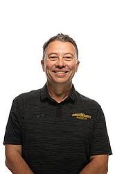 Nestor Osorio stands in front of a white background. He smiles at the camera.